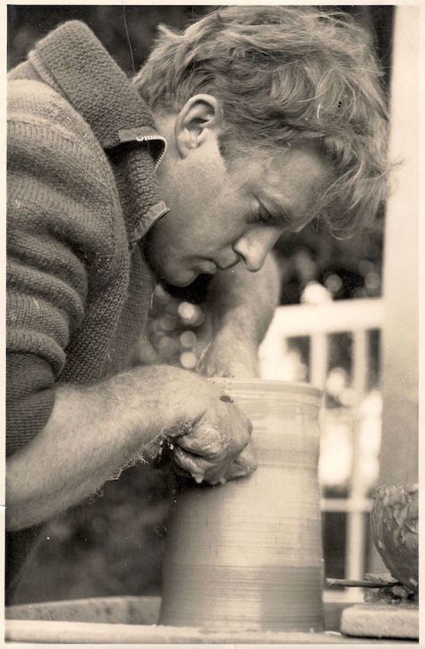 Black and white photograph of Christopher Charman making a pot out of clay